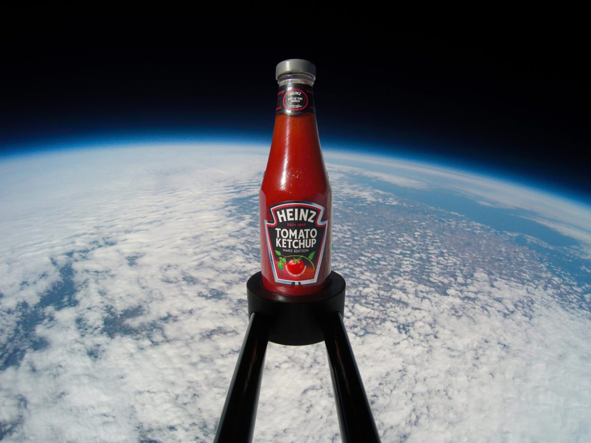 A bottle of Heinz Tomato Ketchup, Marz Edition, is seen on an extended platform well above Earth.