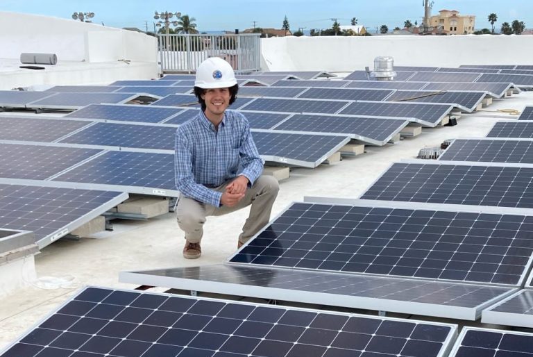 Zachary Eichholz ’16, ’19 M.S., deputy community and economic development director and sustainability manager for the City of Cape Canaveral, with the city’s first solar array, atop the community center.